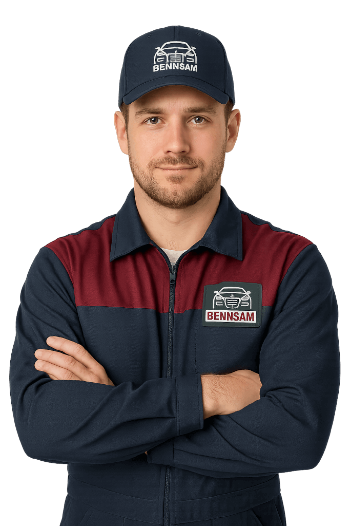 Mechanik Bennsam Przemyśl w czapce z logo, stojący ze skrzyżowanymi rękami